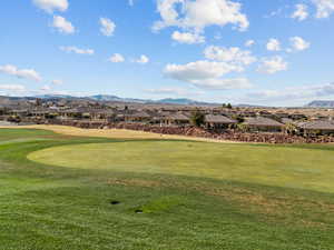 Surrounding community with a residential view, view of golf course, a mountain view, and a lawn