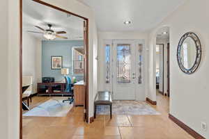 Foyer with baseboards, arched walkways, ceiling fan, stone tile flooring, and recessed lighting