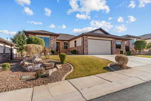 Prairie-style home featuring a garage, brick siding, concrete driveway, a tiled roof, and a front lawn