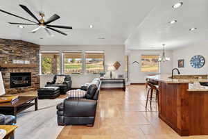 Living area with recessed lighting, visible vents, a stone fireplace, and baseboards