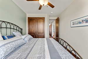 Bedroom featuring ceiling fan and a textured ceiling