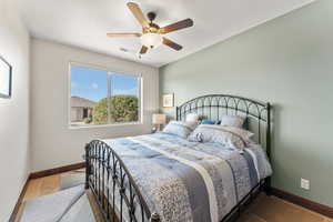 Bedroom with ceiling fan, a textured ceiling, visible vents, and baseboards