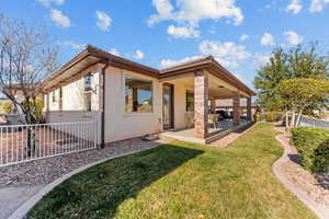 Rear view of property with a patio area, a yard, a fenced backyard, and stucco siding