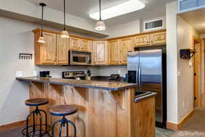 Kitchen featuring, granite countertops, a kitchen breakfast bar, a peninsula, and stainless steel appliances