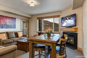 Dining area featuring a gas fireplace, carpet flooring, and baseboards