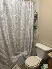 Unit 2 Bathroom featuring vanity, tile patterned flooring, toilet, and shower / tub combo with curtain