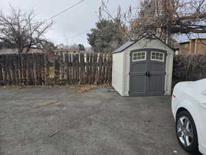 View of shed featuring fence