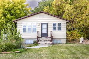 Bungalow-style house with entry steps and a front lawn