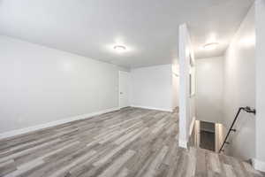 Below grade area with light wood-style flooring and baseboards