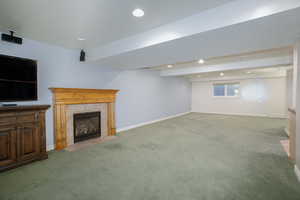 Basement with recessed lighting, light carpet, a fireplace, and baseboards