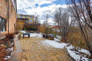 Snow covered patio featuring fence and a pergola