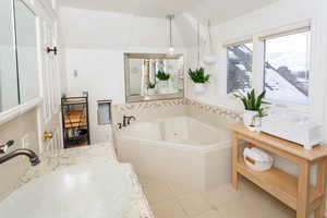 Bathroom featuring a jetted tub, vanity, and tile patterned floors