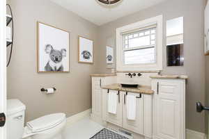 Bathroom featuring toilet, visible vents, baseboards, vanity, and tile patterned floors