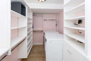 Spacious closet featuring washing machine and dryer and light tile patterned flooring