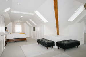 Bedroom with vaulted ceiling with skylight, light carpet, and recessed lighting