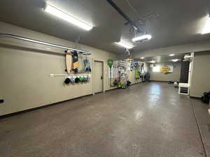 Garage featuring a garage door opener and baseboards