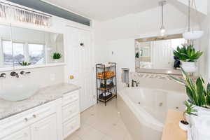 Full bath with tile patterned floors, a tub with jets, and vanity