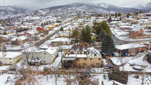 Snowy aerial view featuring a residential view and a mountain view