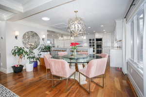 Dining area featuring recessed lighting, crown molding, wood finished floors, baseboards, and an inviting chandelier