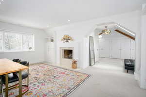 Office space featuring recessed lighting, light colored carpet, a premium fireplace, vaulted ceiling, and baseboards