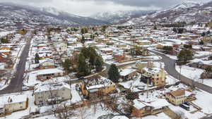 Snowy aerial view featuring a residential view and a mountain view