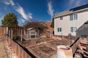 Exterior space featuring a fenced backyard, a shingled roof, and an outdoor structure