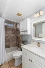 Full bath with shower / tub combo, visible vents, toilet, tile patterned floors, and vanity