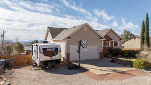 View of front of property with driveway, a garage, roof with shingles, fence, and brick siding