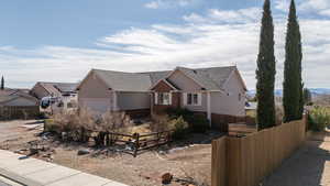 View of front of house with a shingled roof, a fenced front yard, and an attached garage