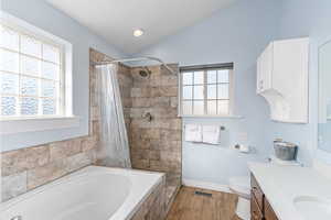 Full bathroom with visible vents, lofted ceiling, wood finished floors, a garden tub, and vanity