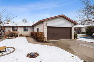 View of front of property featuring an attached garage, driveway, and brick siding