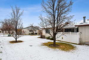 Yard covered in snow with fence