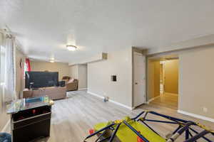 Interior space with visible vents, light wood-style flooring, baseboards, and a textured ceiling