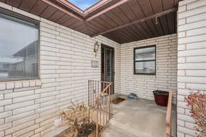 View of exterior entry featuring brick siding