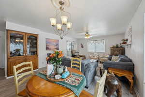 Dining area featuring wood finished floors and ceiling fan with notable chandelier