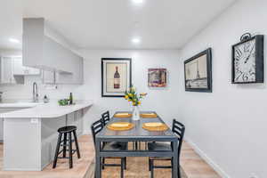 Dining space with light wood-style flooring, baseboards, and recessed lighting