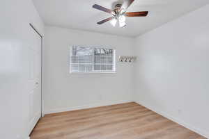 Unfurnished room with light wood-style floors, ceiling fan, and baseboards