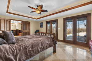 Bedroom featuring baseboards, a raised ceiling, and access to exterior