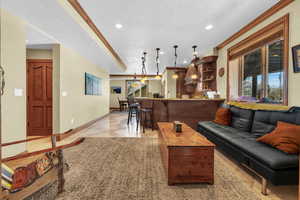 Living area with wet bar, baseboards, a textured ceiling, and ornamental molding