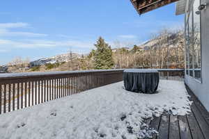 Snow covered deck featuring a mountain view