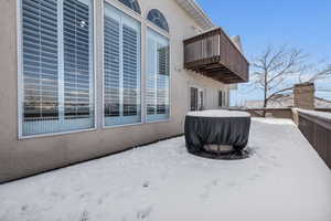 Snow covered patio with a balcony