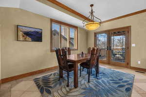 Dining space featuring light tile patterned floors, visible vents, baseboards, french doors, and ornamental molding