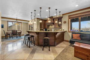 Kitchen featuring pendant lighting, custom range hood, a peninsula, and a kitchen bar