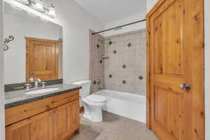 Full bathroom featuring shower / bath combination, tile patterned flooring, toilet, and vanity