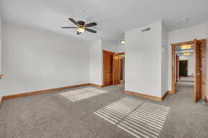 Unfurnished bedroom with visible vents, ceiling fan, light carpet, and baseboards