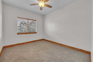 Spare room with carpet floors, baseboards, and a ceiling fan