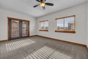 Empty room featuring french doors, carpet flooring, and baseboards