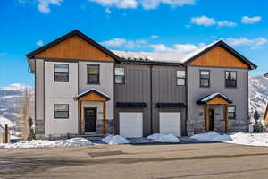 View of front of home featuring stone siding, an attached garage, and a mountain view