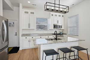 Kitchen with glass insert cabinets, white cabinetry, and appliances with stainless steel finishes