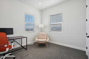 Home office featuring dark colored carpet, recessed lighting, visible vents, and baseboards